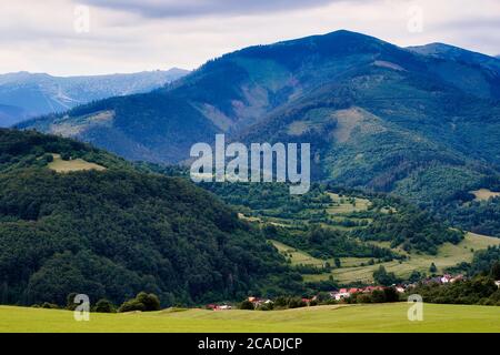 Myto pod Dumbierom village beneath Chopok mountain in the Low Tatras, Slovakia, with a green forested valley. Stock Photo