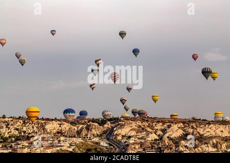 Goreme, Cappadocia, Turkey - May 08, 2014: Kapadokya Hot air balloons flying over famous rock formations landscape of Goreme National Park in Cappadoc Stock Photo