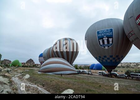 Goreme, Cappadocia, Turkey - May 08, 2014: Kapadokya Hot air balloons flying over famous rock formations landscape of Goreme National Park in Cappadoc Stock Photo