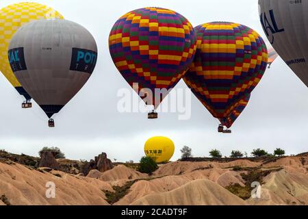 Goreme, Cappadocia, Turkey - May 08, 2014: Kapadokya Hot air balloons flying over famous rock formations landscape of Goreme National Park in Cappadoc Stock Photo