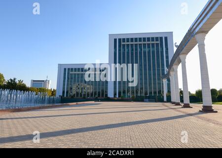 Ministry of Finance of Uzbekistan modern building and Arch of Ezgulik in the Independence Square, also know as Mustaqillik Maydoni in Tashkent. Stock Photo
