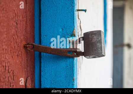 old padlock iron lock on a wooden door, close-up Stock Photo
