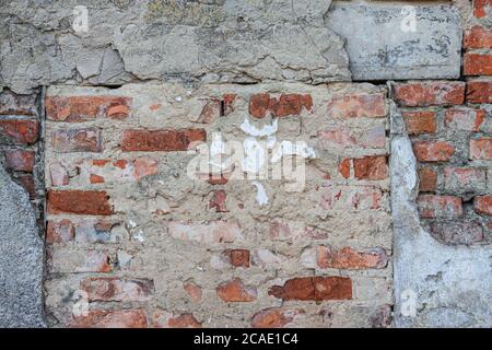 background from the texture of an old brick wall with ruined concrete. Stock Photo