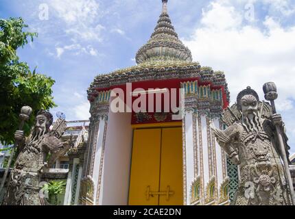 Two chinese stone guardian statues at Wat Pho buddhist temple complex door in Bangkok, Thailand Stock Photo