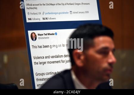 The tweets from Portland Mayor Ted Wheeler are displayed behind acting United States Secretary of Homeland Security Chad F. Wolf, who is appearing before the US Senate Homeland Security and Governmental Affairs Committee on August 6, 2020 in Washington, DC to explain the use of federal agents during protests in Portland, Oregon. Credit: Toni Sandys/Pool via CNP/MediaPunch Stock Photo