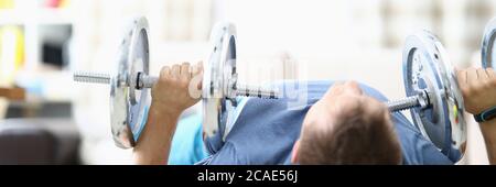 Man doing strength exercises with dumbbells home Stock Photo