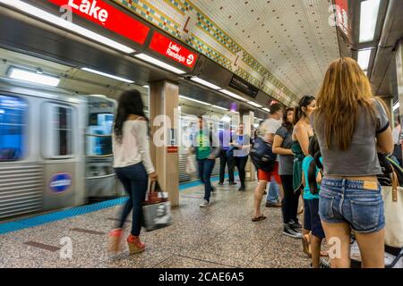 People on the platform of Lake Station on the Chicago El, with a train passing through. Stock Photo