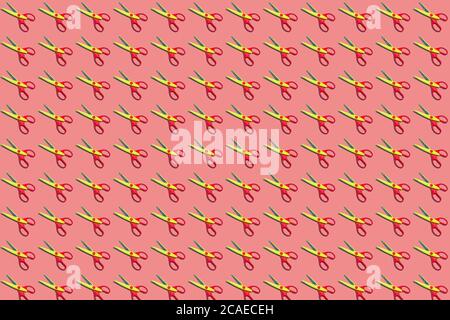 Seamless colorful pattern of open plastic yellow and red scissors on pastel pink color background. From top view. Flat lay Stock Photo
