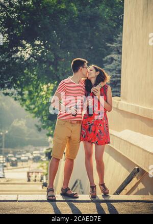 ODESSA, UKRAINE - OCTOBER 15, 2014: Happy young couple hugging and kissing outdoors summertime drinking cold Pepsi from glass bottles with straw Stock Photo