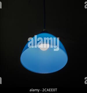 Ceiling lamp with blue lampshade on a black background. Background. Stock Photo