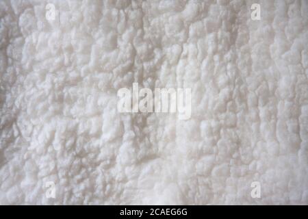 White soft wool background, detail of a natural sheepskin rug. Stock Photo