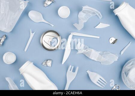 White single use plastic on blue background. Environmental, pollution concept. Stock Photo