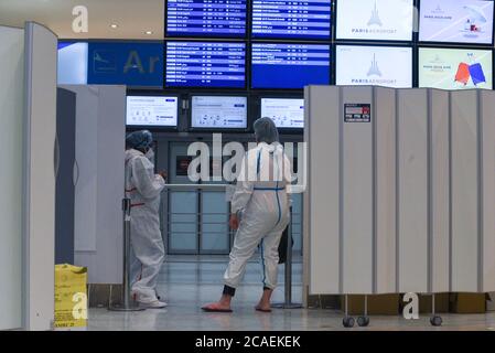 *** STRICTLY NO SALES TO FRENCH MEDIA OR PUBLISHERS - RIGHTS RESERVED ***August 04, 2020 - Paris, France: Health workers in full protective gears wait for passengers near the Arrivals Gate at Charles-de-Gaulle airport. French authorities began on August 01 compulsory covid-19 testing on arrival for passengers from 16 countries where the coronavirus virus is circulating widely. Stock Photo