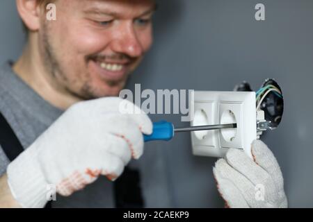 Handyman using screwdriver to install sockets Stock Photo