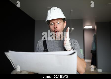 Shocked handyman or engineer looking at scheme Stock Photo