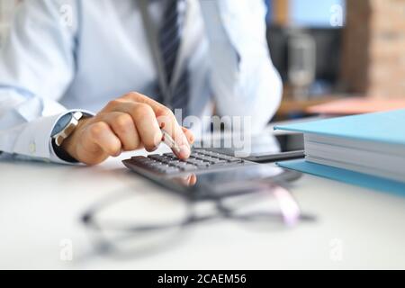 Hand of male businessperson making calculations Stock Photo