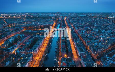 Aerial panoramic view of Amsterdam city in evening. Famous Dutch channels and dancing houses from above. Netherlands, Europe. Stock Photo