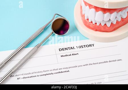 Dental history form with model tooth and dental instruments. Dental health and teeth care concept. Stock Photo