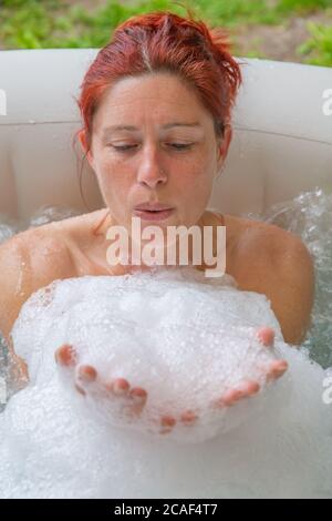 Portrait of Pretty natural redheaded woman relaxing in her jacuzzi Stock Photo