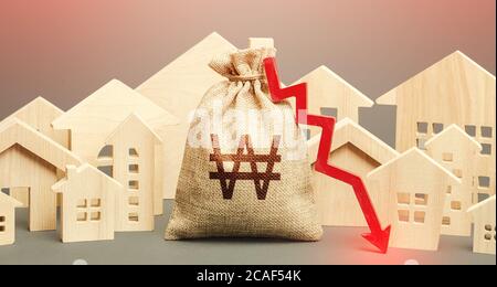 City residential buildings and south korean won money bag with a red down arrow. Low demand for home buying. Lower mortgage interest rates. Falling pr Stock Photo