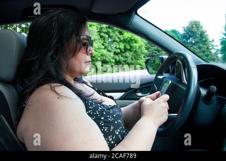 person dialling on their cell phone while inside their automobile Stock Photo