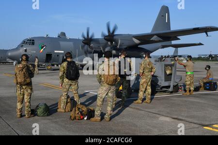 Air Commandos with the 73rd Special Operations Squadron wait to board an AC-130J Ghostrider gunship during an engine run crew change at Hurlburt Field, Florida, Aug. 5, 2020. During an engine run crew change, the motors of the aircraft remain on as the crews change out before the aircraft takes off again. (U.S. Air Force photo by Airman 1st Class Hailey M. Ziegler) Stock Photo
