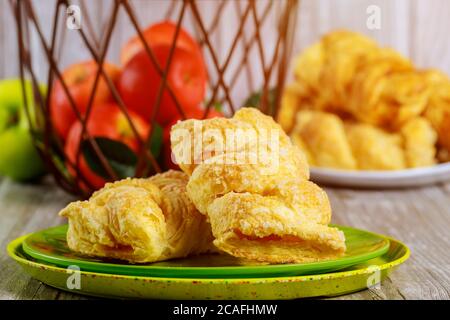 Apple strudel with fresh red and green apples in basket on wooden table. Stock Photo