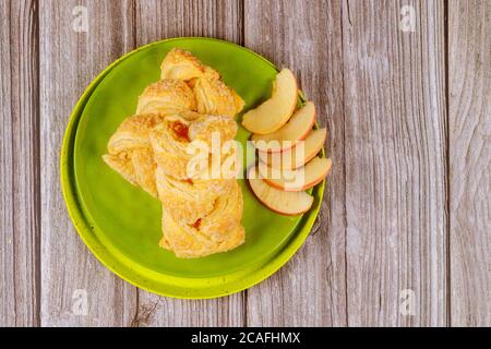 Two apple strudel with sliced fresh red apples on wooden table. Stock Photo