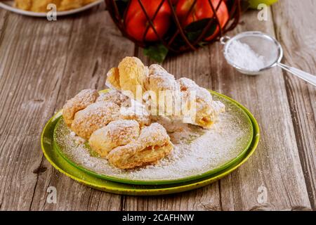 Powdered sugar sprinkle on apple strudel with fresh apples in wire basket. Stock Photo