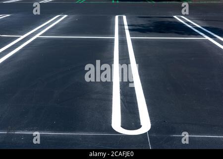A newly completed outdoor parking lot with freshly painted white and green lines to mark the stalls. Stock Photo