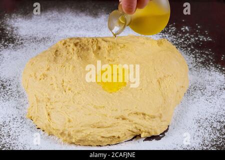 Woman pouring oil on dough for making homemade pasta. Stock Photo