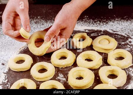Making sweet donuts and munchkins from raw yeast dough. Stock Photo