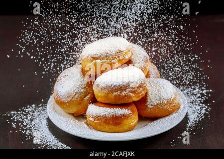 Homemade american donuts sprinkling with powder sugar in white plate. Stock Photo