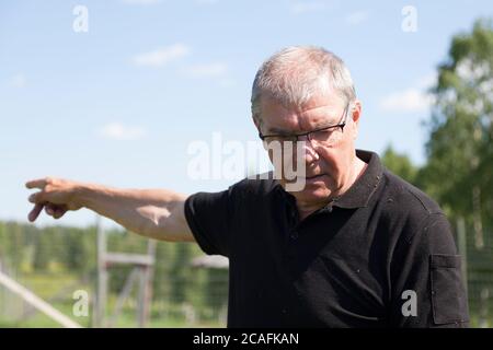 Bjurholm, Norrland Sweden - July 6, 2020: older man points out direction Stock Photo