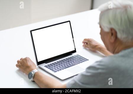 Close-up Of Senior Man Using Laptop Showing Blank Screen At Home Stock Photo