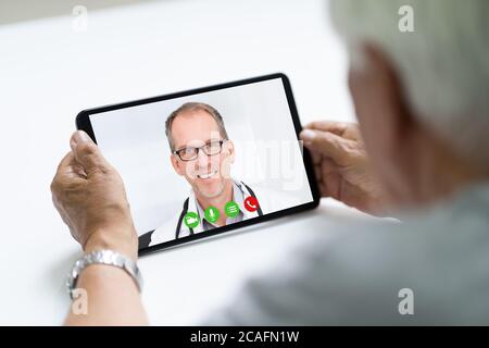 Senior Man In Videochat Or Videoconference With Doctor On Tablet Stock Photo