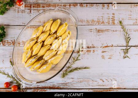 Jumbo pasta shells stuffed with ricotta cheese, meat and tomato sauce in oven pan. Stock Photo