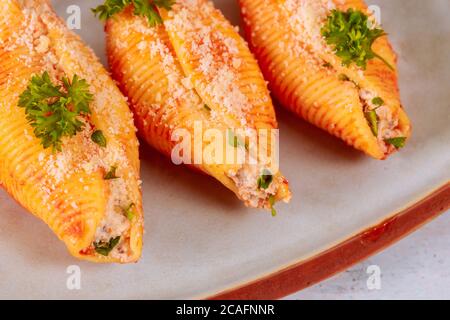 Three mega shells jumbo pasta on plate, stuffed with ricotta. Close up. Stock Photo