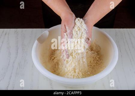 Chef kneading flour, sugar and butter with hands for making cookie dough. Stock Photo
