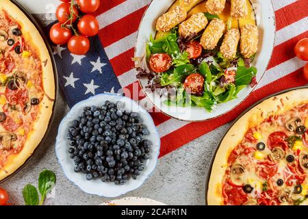 Memorial Day party table with delicious food and flag for american holiday. Stock Photo