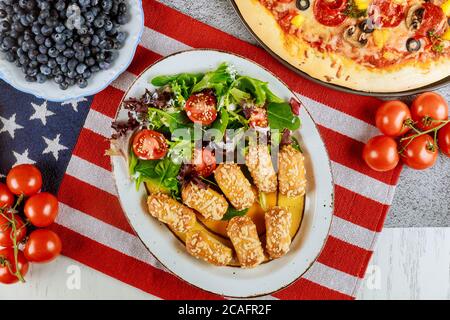 Independence Day party table with delicious food and flag for american holiday. Stock Photo