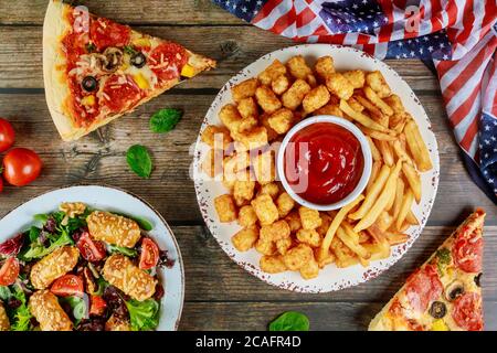 Festive party table with fried potato, pizza and vegetable for american holiday Memorial Day. Stock Photo