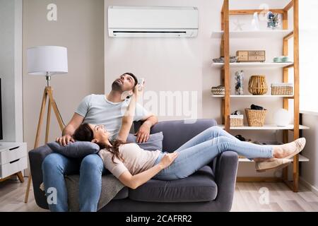 Happy Woman Holding Air Conditioner Remote Control Stock Photo