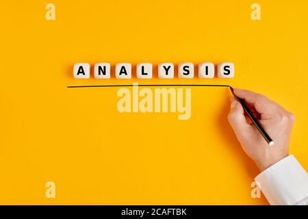 Male hand is writing the word analysis on yellow background. Stock Photo