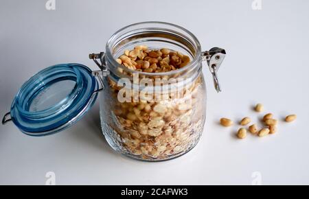 Fried peanuts in a jar on white background. Stock Photo