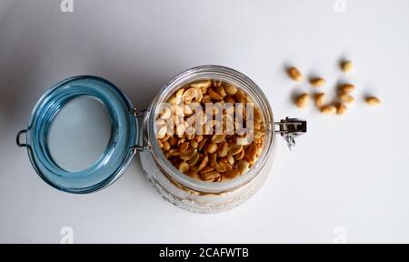 Fried peanuts in a jar on white background. Stock Photo