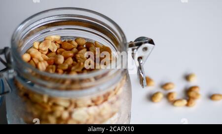 Fried peanuts in a jar on white background. Stock Photo