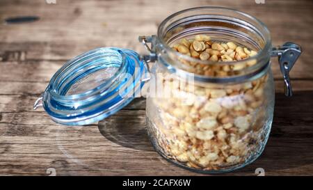 Fried peanuts in a jar on wood background. Stock Photo