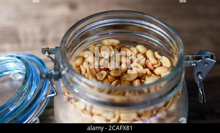 Fried peanuts in a jar on wood background. Stock Photo