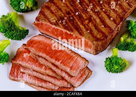 Sliced grilled roasted rare beef with broccoli on white plate. Stock Photo